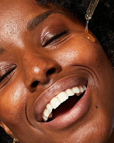 Close-up of a woman applying facial serum.